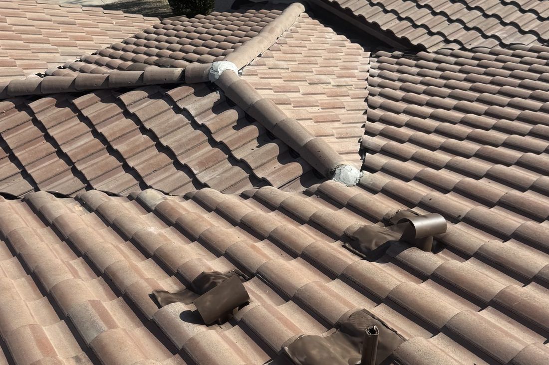 Close-up of a Phoenix concrete tile roof showing deteriorated pipe flashing boots that are a common source of leaks